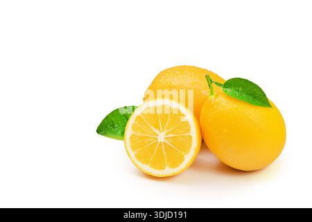 Three lemons with a leaf on top. One of the lemons is cut in half. The lemons are sitting on a white background Stock Photo