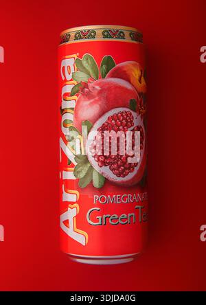 LONDON,UK - OCTOBER 21, 2025: Arizona green iced tea drink with pomegranate flavor on red background. Stock Photo