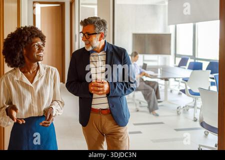 Happy business professionals discussing growth plans and goals while collaborating in modern office Stock Photo