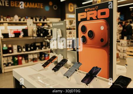 Smartphones on display table with promotional stand for new mobile model inside electronics store in Belgrade. Belgrade, Serbia - January 15, 2026. Stock Photo