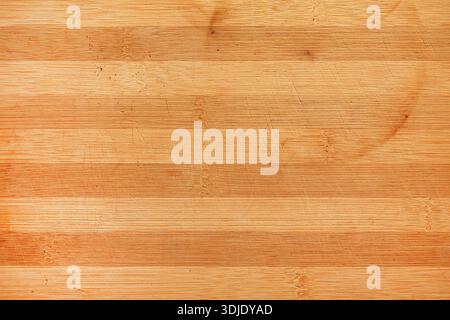 Texture of wooden chopping board photographed from above, natural kitchen background with visible grain and worn surface details. Stock Photo