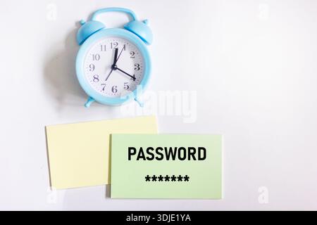 A secret password written on a sticker next to the alarm clock on a white background Stock Photo