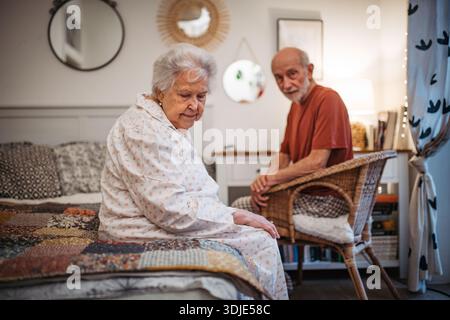 Elderly spouses sharing quiet moment before sleep. Stock Photo