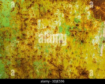 Weathered steel surface exhibits rust and peeling paint in an industrial outdoor setting. Aged appearance conveys a sense of grunge and distress under daylight. Stock Photo