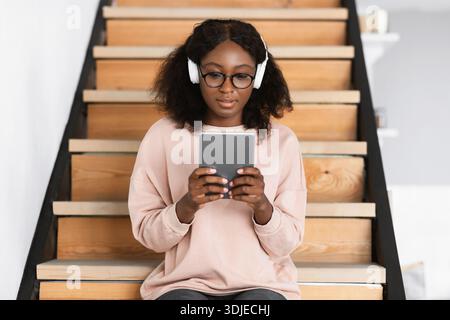 African American Student Lady Using Digital Tablet At Home Stock Photo