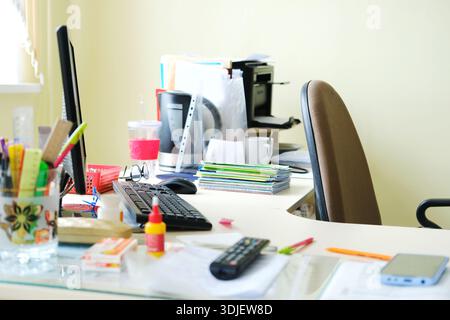 A teacher's desk in a lively classroom, showcasing colorful stationery, a computer, and neatly arranged materials, fostering an engaging educational a Stock Photo
