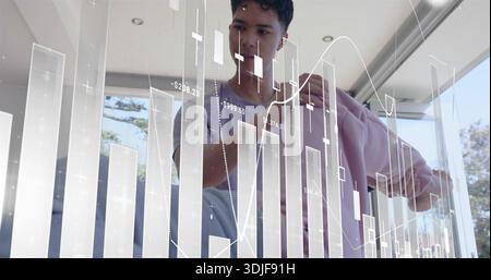 Standing adult male holding pink jacket, studying financial chart overlay on glass in modern room Stock Photo