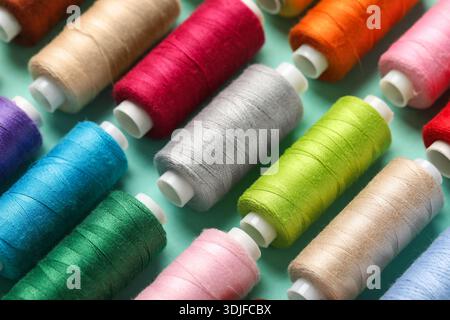 Set of different thread spools on mint background, closeup Stock Photo
