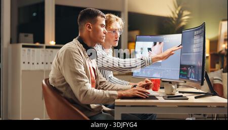 Men, designers or night with computer for deadline, digital marketing or editing in office. Male people, creative team or editor working late on Stock Photo