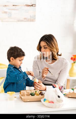 Mother and child colouring Easter eggs Stock Photo