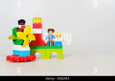 Brightly colored toy building blocks with playful figures, showcasing a flower design, set against a clean white background, providing ample copy spac Stock Photo