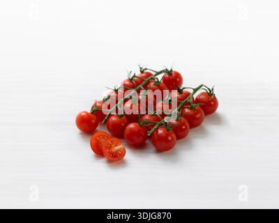 Cherry tomatoes on branches on a white background Stock Photo