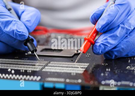 Technician under fixed and repairing computer mainboard process by used multimeter AC Voltage for analysis on computer mainboard is electronic compone Stock Photo
