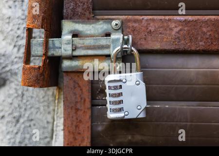 Silver combination padlock on the door. Stock Photo