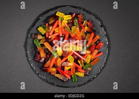 heap jelly candies on stone plate, on dark background. Stock Photo