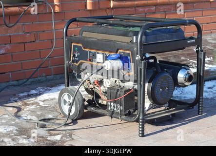 Mobile backup generator near house during winter energy crisis in Ukraine. Stock Photo