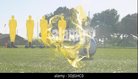 Sitting soccer ball with yellow swirl effect on grass pitch, surrounded by four mannequins and goal Stock Photo
