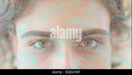 Projecting turquoise binary code across adult woman's face in studio close-up, reflecting in eyes Stock Photo