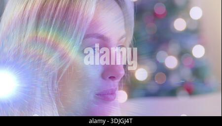 Facing adult woman showing contemplative gaze in living room, lens flare creating rainbow streaks Stock Photo