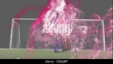 Contesting possession duo in white red or blue socks before goal on turf at night, ball, pink smoke Stock Photo