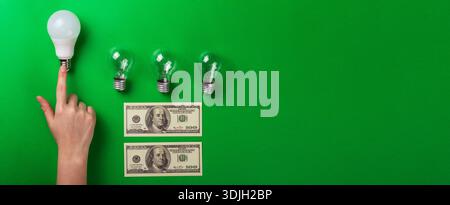 Female hand choice led lamp of set of different types on a green background. Selective focus, noise. Energy-saving lamps Stock Photo