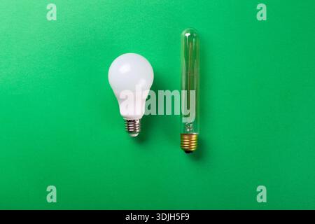 LED lamps and incandescent eddison lamp isolated on a green background. Selective focus, noise. Energy-saving lamps Stock Photo