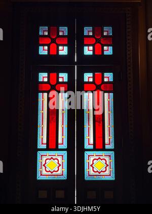Holy Metropolitan Church of the Annunciation, Mitropoleos Square Πλατεία Μητροπόλεως. Interior detail of colourful stained glass panels on a dark wood Stock Photo