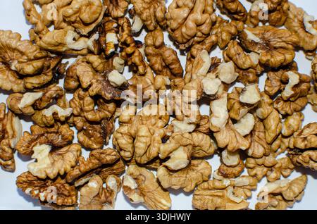 Pile of Walnut Halves Freshly Shelled on a White Surface, Close Up Stock Photo