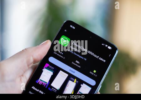 Phone in hand displaying DirectChat - Without save number app on Google Play Store Stock Photo