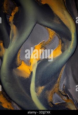 Aerial view of a river with swirling patterns of black sand and golden hues, a dance of nature's artistry, Selfoss, Iceland. Stock Photo