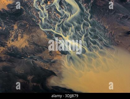 Aerial view of braided rivers create intricate patterns against the dark earth, a stunning display of nature's artistry, Selfoss, Iceland. Stock Photo