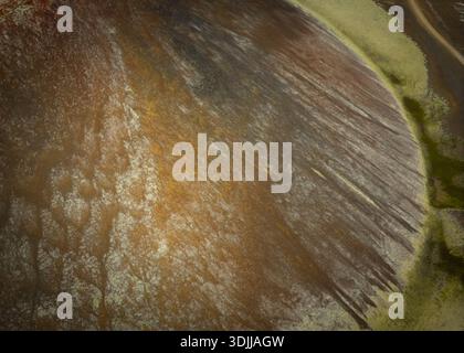 Textured earth ground with soil craters and wheel tracks next to a ...