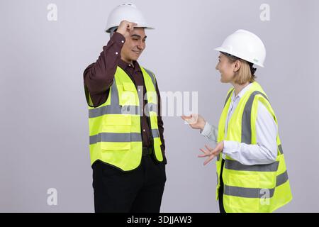 Two construction workers in safety vests talking together Stock Photo