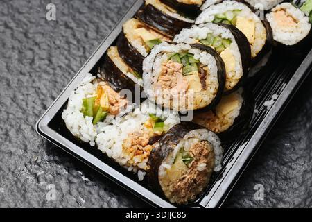 Sushi takeaway set in plastic container closeup. Japanese food rolls with rice and fish. Ready to eat Asian cuisine delivery concept. Stock Photo
