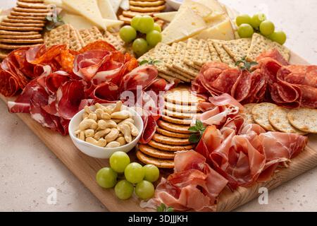 Charcuterie and cheese board with variety of meat and cheeses, crackers and nuts, honey and grapes Stock Photo