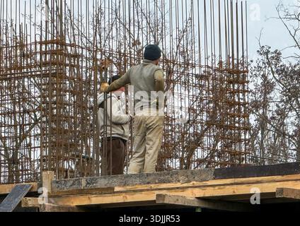 Construction workers standing on a reinforced concrete structure, Donetsk Oblast, Mariupol, Ukraine Stock Photo