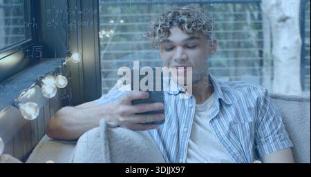 Reclining man in striped shirt and white tee, holding smartphone on sofa with lights, math-overlay Stock Photo