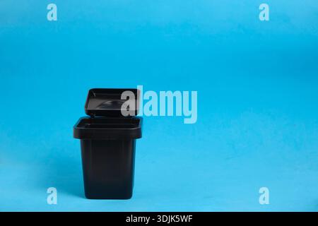 Universal storage container or desktop trash can on bright blue background Stock Photo