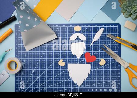Making a gnome in love craft. All cut-out pieces are lying on pink cutting mat. Stock Photo
