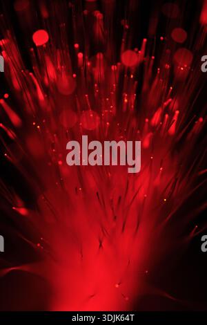 Expressive stream of bright red light emanating from bundle of optical cables Stock Photo