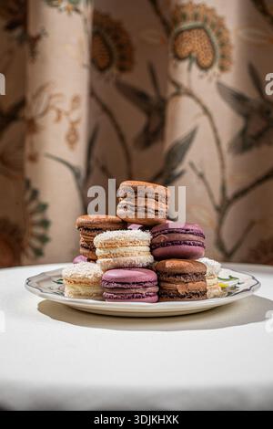 Assorted macarons stacked on decorative plate Stock Photo