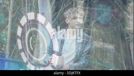 Leaning male in plaid shirt on deck among thin trunks, touching holographic interface, copy space Stock Photo