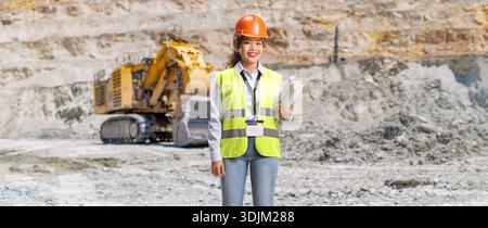 Female engineer holding blueprints at a mining site Stock Photo