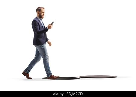 Distracted businessman walking into an open manhole while using a smartphone isolated on white background Stock Photo