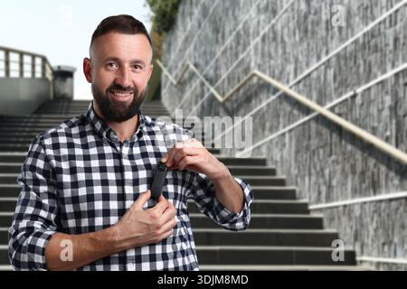 Man with hidden spy camera in his pocket going downstairs outdoors Stock Photo