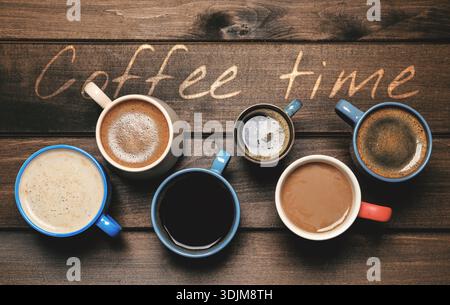 Coffee break time. Hot aromatic beverages in cups on wooden table, top view Stock Photo