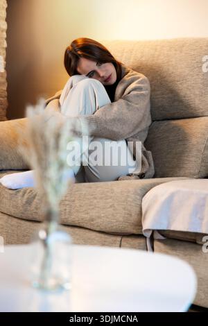 Sad woman experiencing anxiety and solitude at home Stock Photo