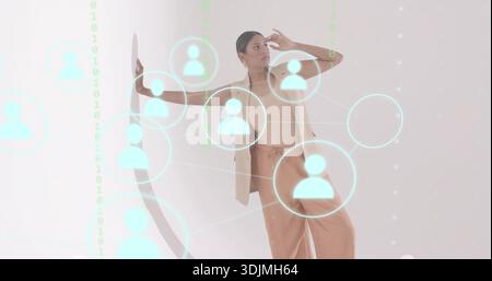 Reaching woman wearing beige blazer, tan trousers at studio with cyan nodes and lines, green binary Stock Photo