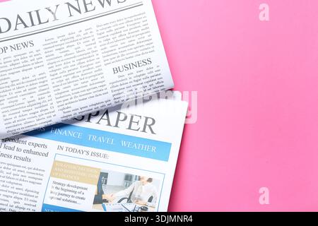 Different newspapers on pink background Stock Photo