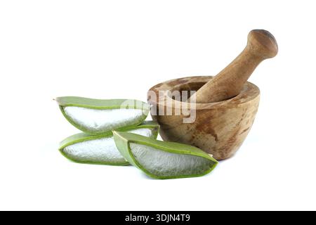 Fresh aloe vera slices arranged beside a vintage wooden mortar and pestle, isolated on white. Stock Photo